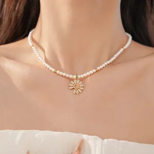 Detailansicht einer 18k vergoldeten Perlenkette mit einem Zirkonia-Gänseblümchen-Anhänger.