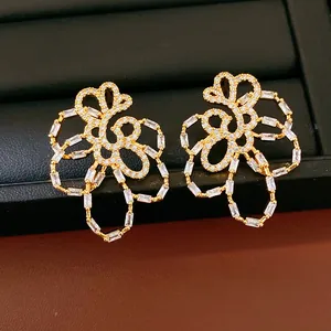 Detail of 18k gold plated hollow flower stud earrings with brilliant zircon stones