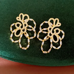 Close-up of gold-plated flower stud earrings with sparkling cubic zirconia stones