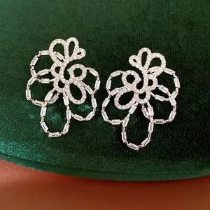 Close-up of sparkling hollow flower stud earrings with exquisite baguette-cut zircons