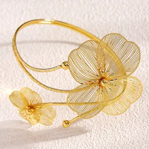Vista dettagliata di un bracciale da braccio regolabile in oro con intricati motivi floreali.