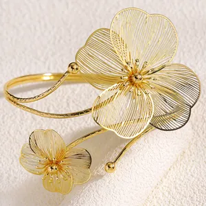Dettaglio di un bracciale da braccio a fiori dorati traforati con design regolabile