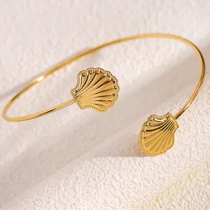 Primo piano del bracciale a conchiglia dorata con dettagli strutturati su sfondo bianco