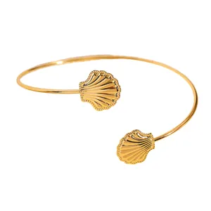 Vista dettagliata di un elegante bracciale da braccio dorato con design a conchiglia aperta.