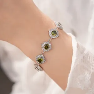 Dettaglio di un elegante bracciale in argento con zirconi verdi incastonati a fiori