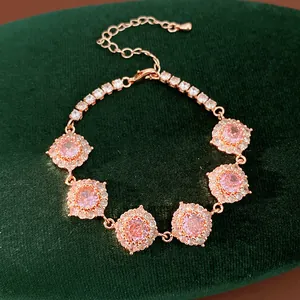 Primo piano di un bracciale in oro rosa con pietre di zirconia rosa su velluto.