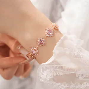 Primo piano di un elegante bracciale in oro rosa con zirconi rosa sul polso del modello