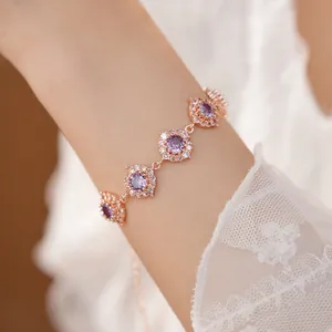 Dettaglio di un bracciale in oro rosa con zirconi viola e trasparenti sul polso