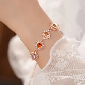 Primo piano dettagliato di un bracciale in oro rosa con zirconi colorati sul polso
