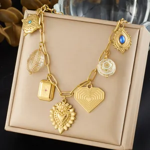 Close-up of ornate gold vintage multi-charm necklace featuring heart and gemstone pendants