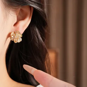 Detalle de un pendiente de flor de circón chapado en oro vintage puesto en la oreja