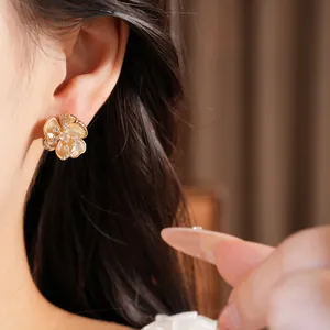Primer plano de pendientes de flores vintage franceses chapados en oro con circonitas