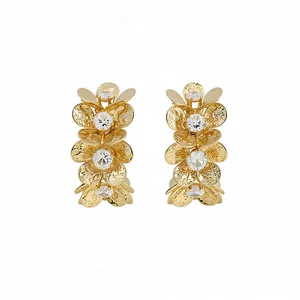 Gold-toned C-shaped hoop earrings featuring textured metal flowers and clear zircon accents