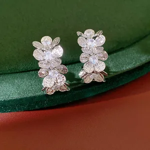 Detailed view of elegant silver-toned C-shaped hoop earrings with sparkling floral CZ petals