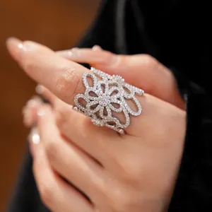 Close-up detail of a luxury cubic zirconia pavé openwork flower ring worn on a finger