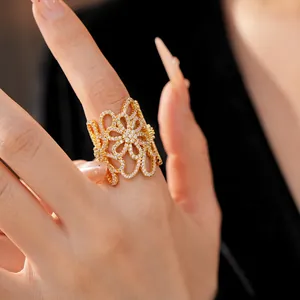 Close-up detail of 18K gold-plated ring with hollow flower design and sparkling cubic zirconia