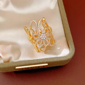 Detailed close-up view of 18K gold plated zirconia hollow flower ring in luxury display box