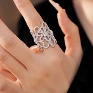 Detailed close-up showing the sparkling zircon hollow flower open ring on a finger.