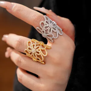 Detail view of 18K gold plated hollow flower rings with zirconias worn on fingers