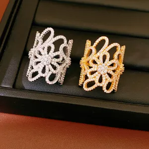 Close-up of gold and silver plated hollow flower rings with sparkling zircon inlay