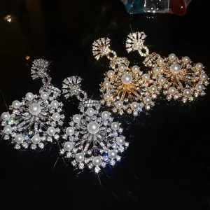 French vintage snowflake earrings with pearls and zircons on a dark reflective surface