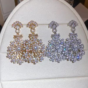 Close-up of vintage snowflake earrings with sparkling zircons and elegant pearls.