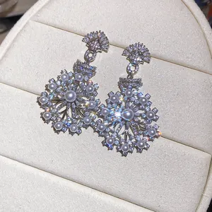 Close-up of French vintage snowflake earrings with zircons and pearls.