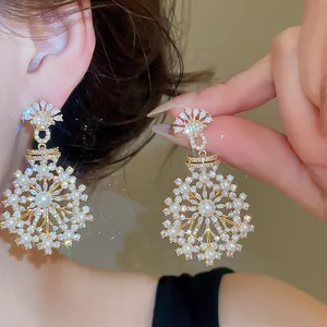 Detailed view of elegant French vintage snowflake earrings with pearls and zircons
