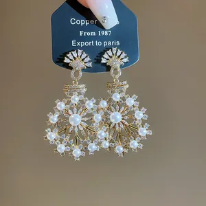 Detailed view of vintage French style snowflake earrings with pearls and zircons