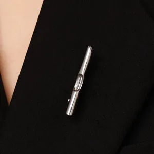 Nahaufnahme einer minimalistischen silbernen DIY-Brosche auf einem schwarzen Revers