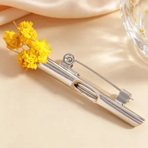 Makroansicht der minimalistischen silbernen Brosche mit gelben Trockenblumen