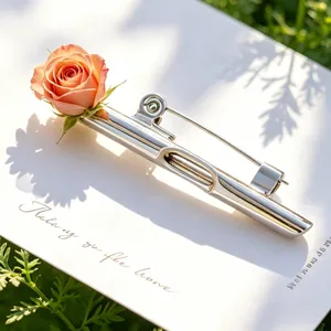 Nahaufnahme einer silbernen DIY-Blumenbrosche mit einer frischen Rose auf Karte