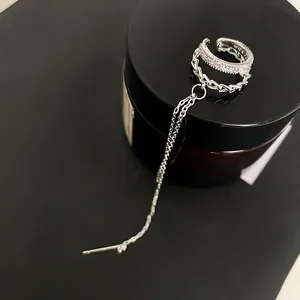 Detail of silver double-layer ear cuff with sparkling zircon and long chain ear line.
