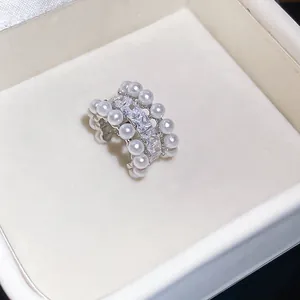 Close-up of elegant ear cuff featuring rows of shimmering pearls and cubic zirconia