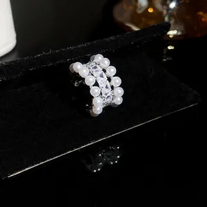 Close-up of elegant ear cuff featuring white pearls and sparkling zircons