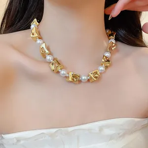 Detailed shot of a gold irregular geometric necklace with white pearls on a model's neck