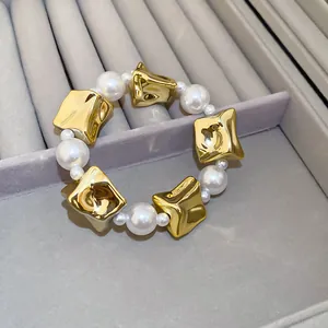 Close-up of elegant bracelet with irregular gold pieces and lustrous white pearls