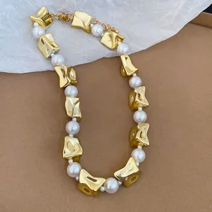 Close-up of fashion statement necklace featuring irregular gold beads and white pearls