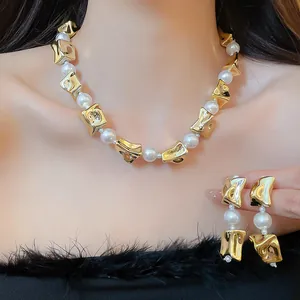 Detailed view of elegant gold irregular metal and pearl necklace with matching earrings