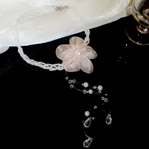 Detail view of an elegant chiffon flower pearl necklace with sparkling crystal tassels.