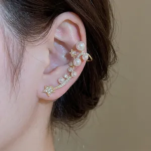Boucle d'oreille manchette élégante avec étoiles, perles et zircons, finition dorée