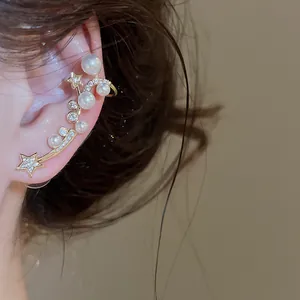 Gros plan sur un earcuff étoile et perle avec des détails en zircon scintillant