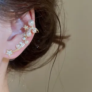 Détail d'une manchette d'oreille élégante avec des perles et des étoiles en zircon