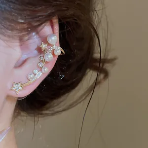 Gros plan détaillé d'un earcuff intégré avec étoiles et perles en zircons brillants