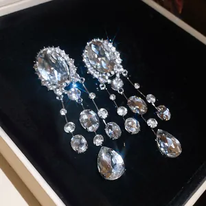 Detail of sparkling oval rhinestone tassel clip-on earrings with waterdrop crystal drops