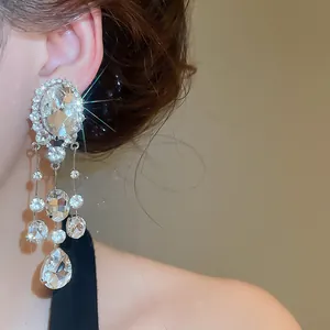 Detail of sparkling oval and teardrop tassel clip-on earrings with elegant rhinestones