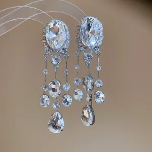 Detailed view of sparkling oval rhinestone tassel clip-on earrings with waterdrop charms.