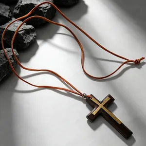 Close-up of vintage wooden cross necklace with gold metal inlay and adjustable rope