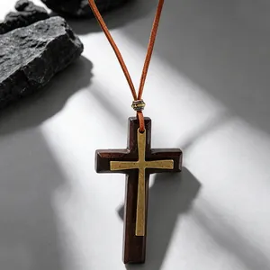 Macro shot of layered wooden cross necklace with metallic gold inlay and suede cord