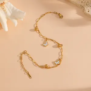 Close-up of gold butterfly anklet with steel beads and delicate white butterfly charms.